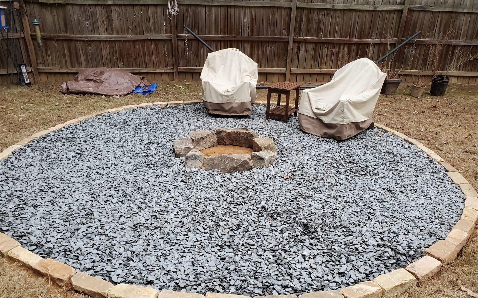 Circular paver patio with a stone fire ring and seating