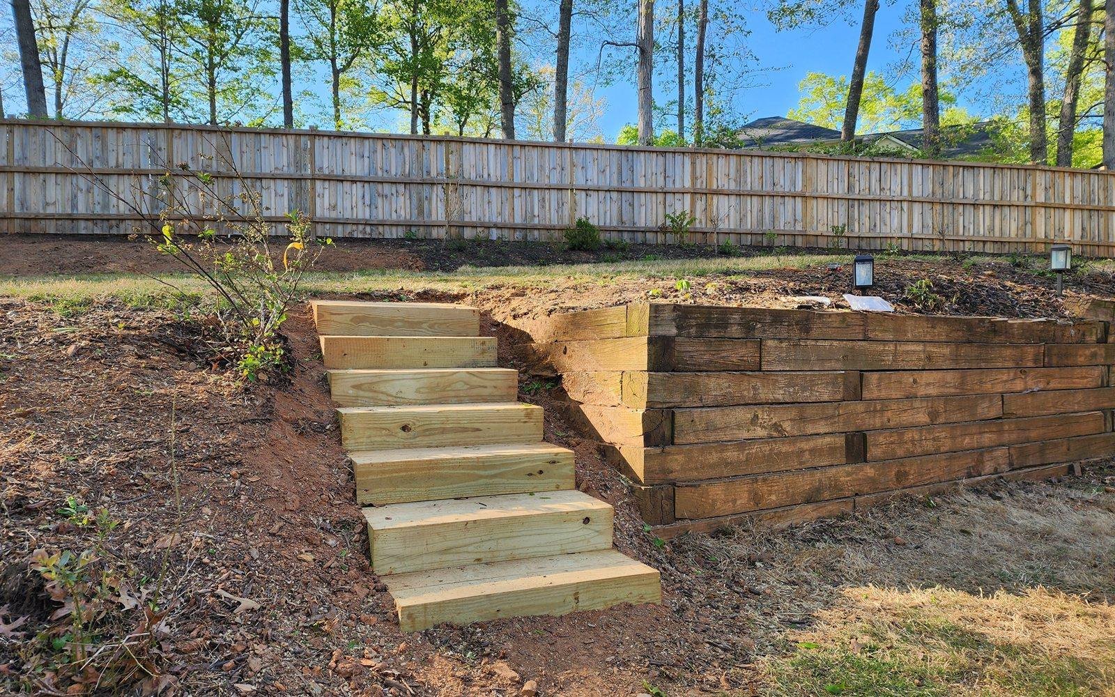 Tiered timber retaining wall with fresh sod on a North Georgia front yard
