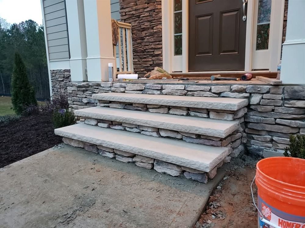 Stacked-stone entry steps with stone-veneer risers at a home's front door