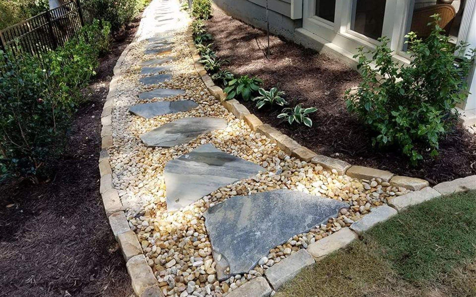 Bluestone and river-rock mosaic pathway with fresh plantings