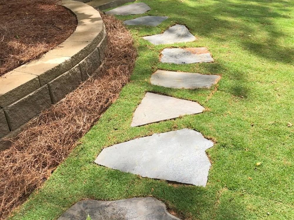 Irregular flagstone stepping-stone path across a green lawn